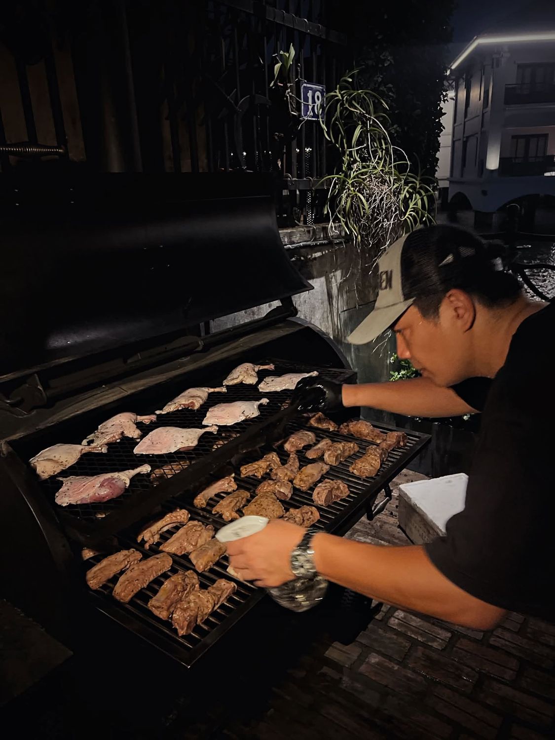 Chef grilling duck and chicken outdoors