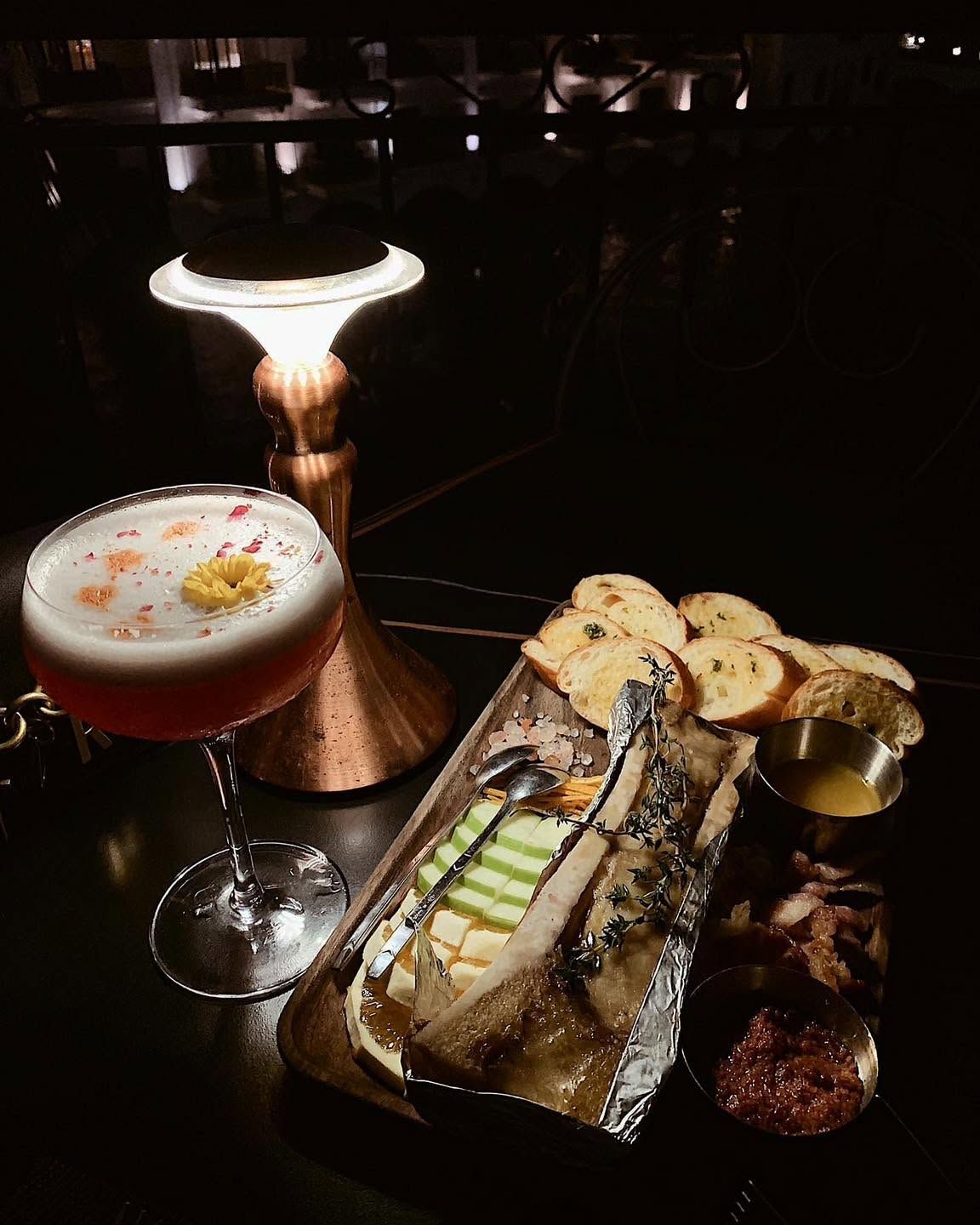 Roasted bone marrow with toast beside a cocktail