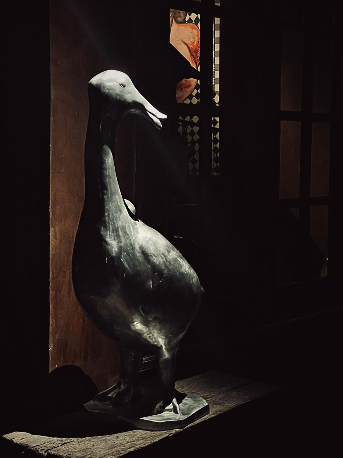 The dark duck sculpture by the window