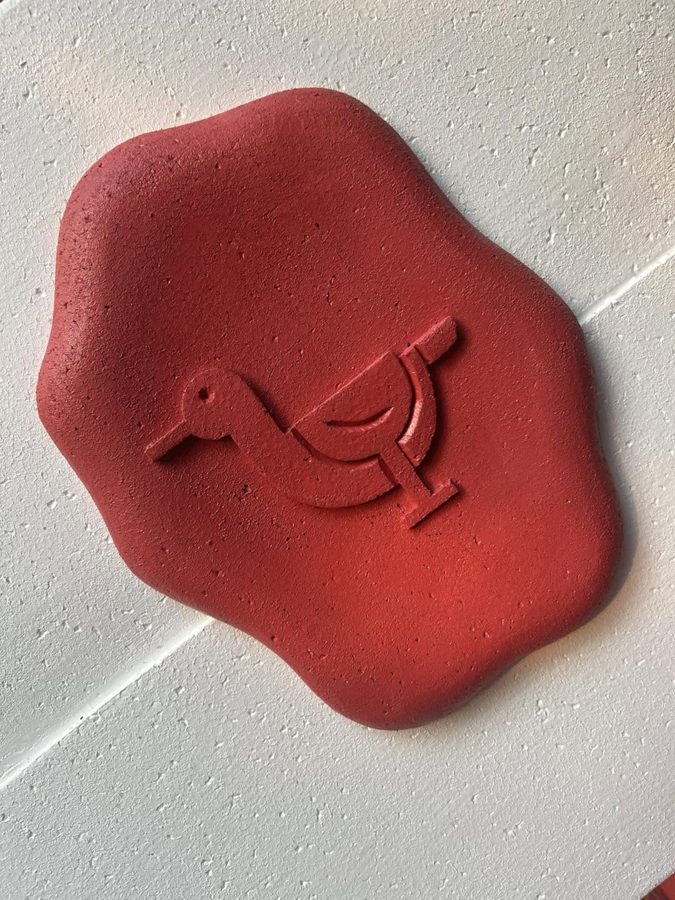 The red duck emblem on a white wall