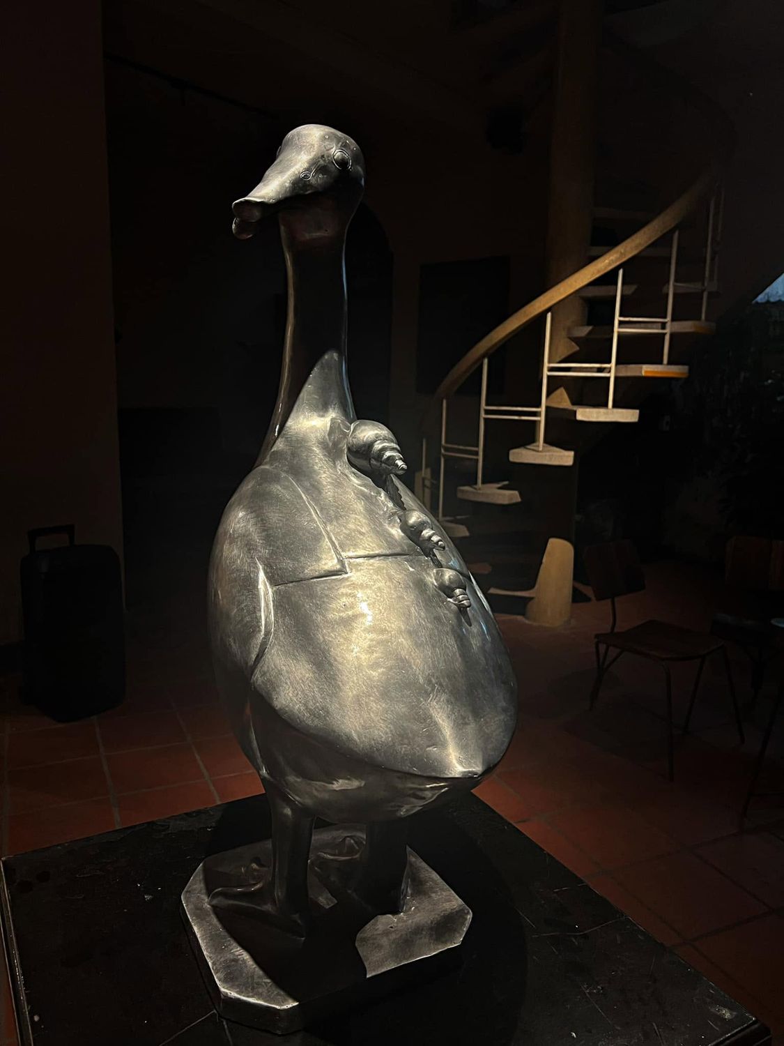 The silver duck sculpture beside the spiral staircase