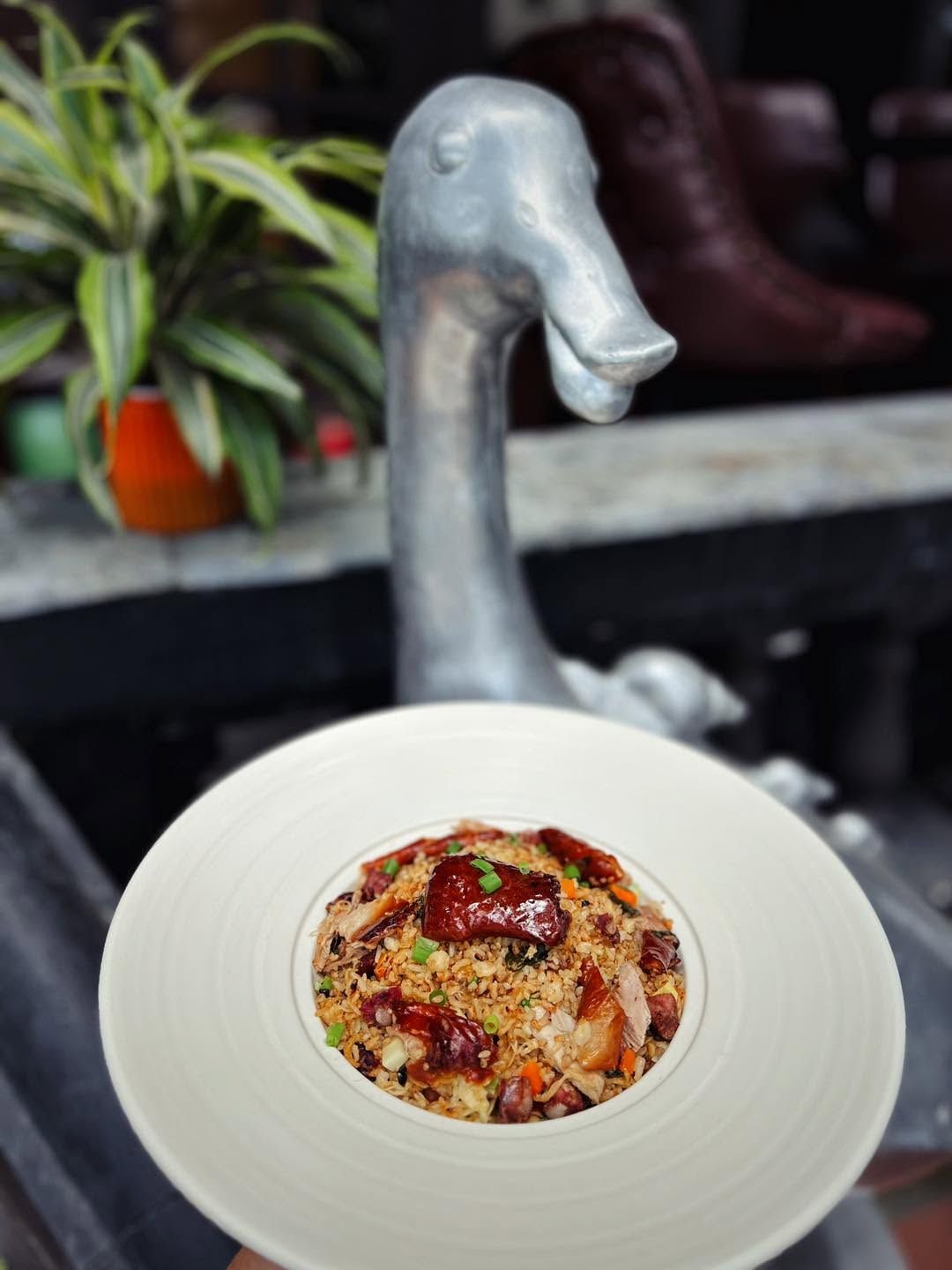 Fried rice with roast duck in front of the silver duck sculpture