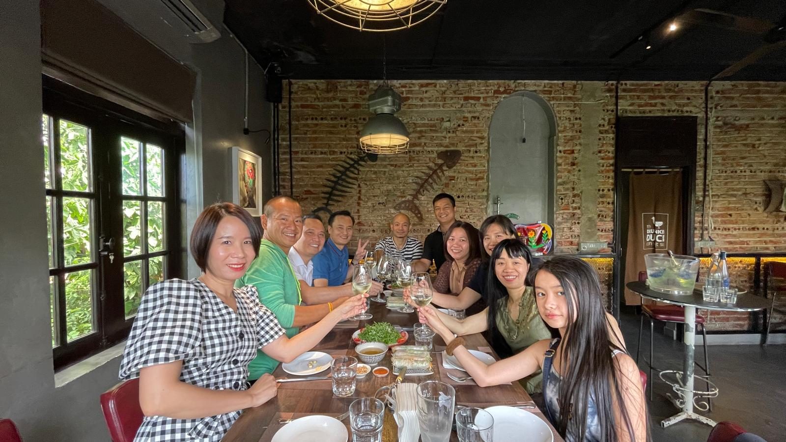 Old colleagues from the FPT Telecom web team raising glasses around a long table inside The Drunken Duck
