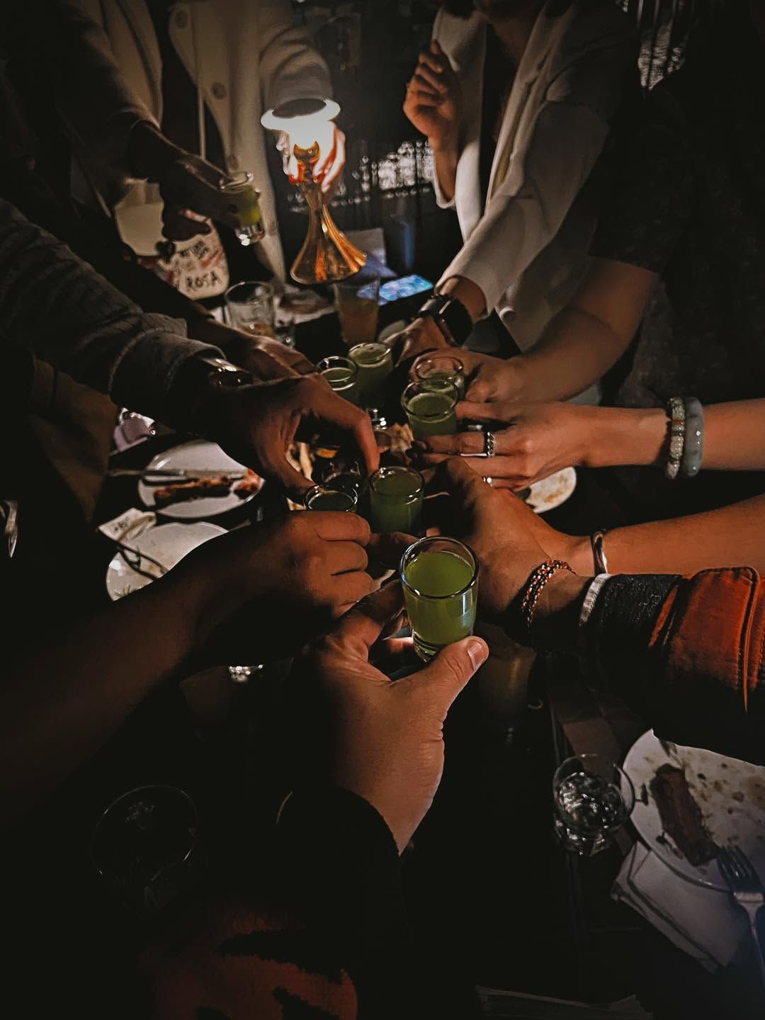 Friends raising shot glasses together