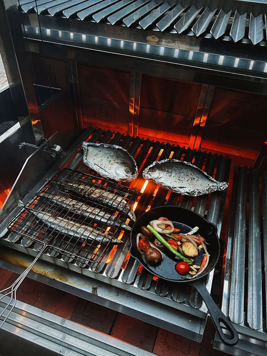 Whole fish and vegetables over charcoal