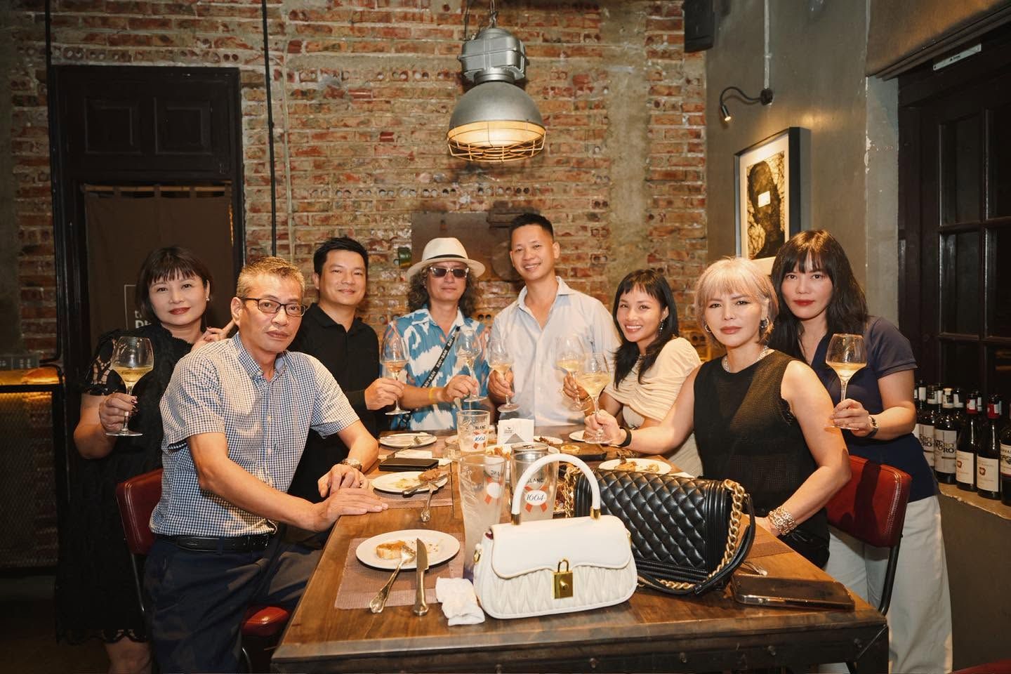 Guests raising glasses at a long table inside