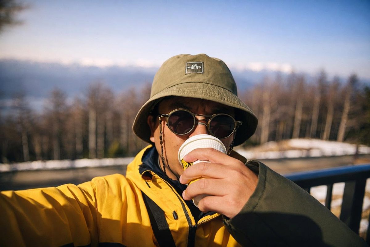 Loija sipping coffee on a snowy mountain lookout