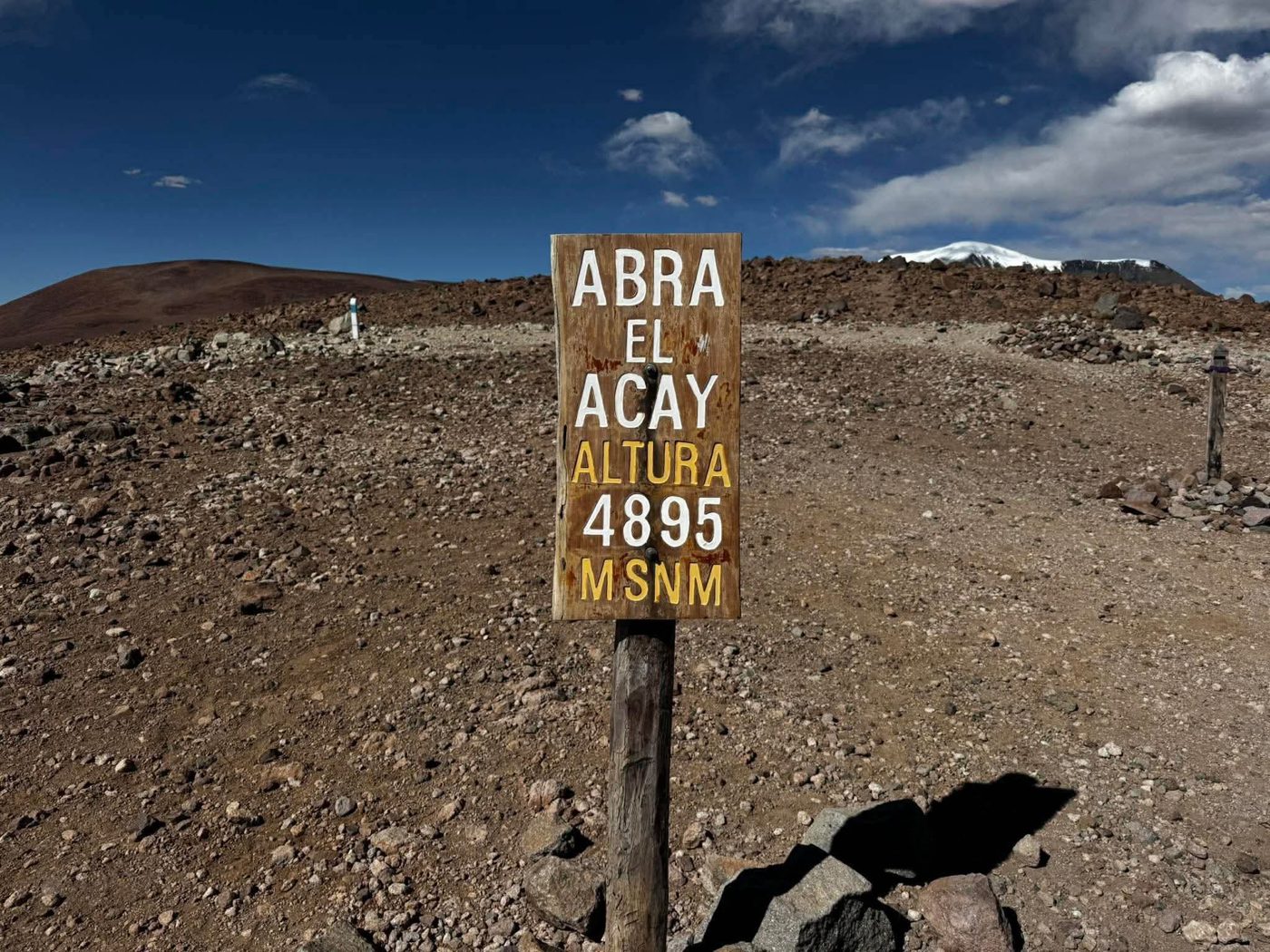 A wooden sign reading Abra el Acay, altitude 4895 metres