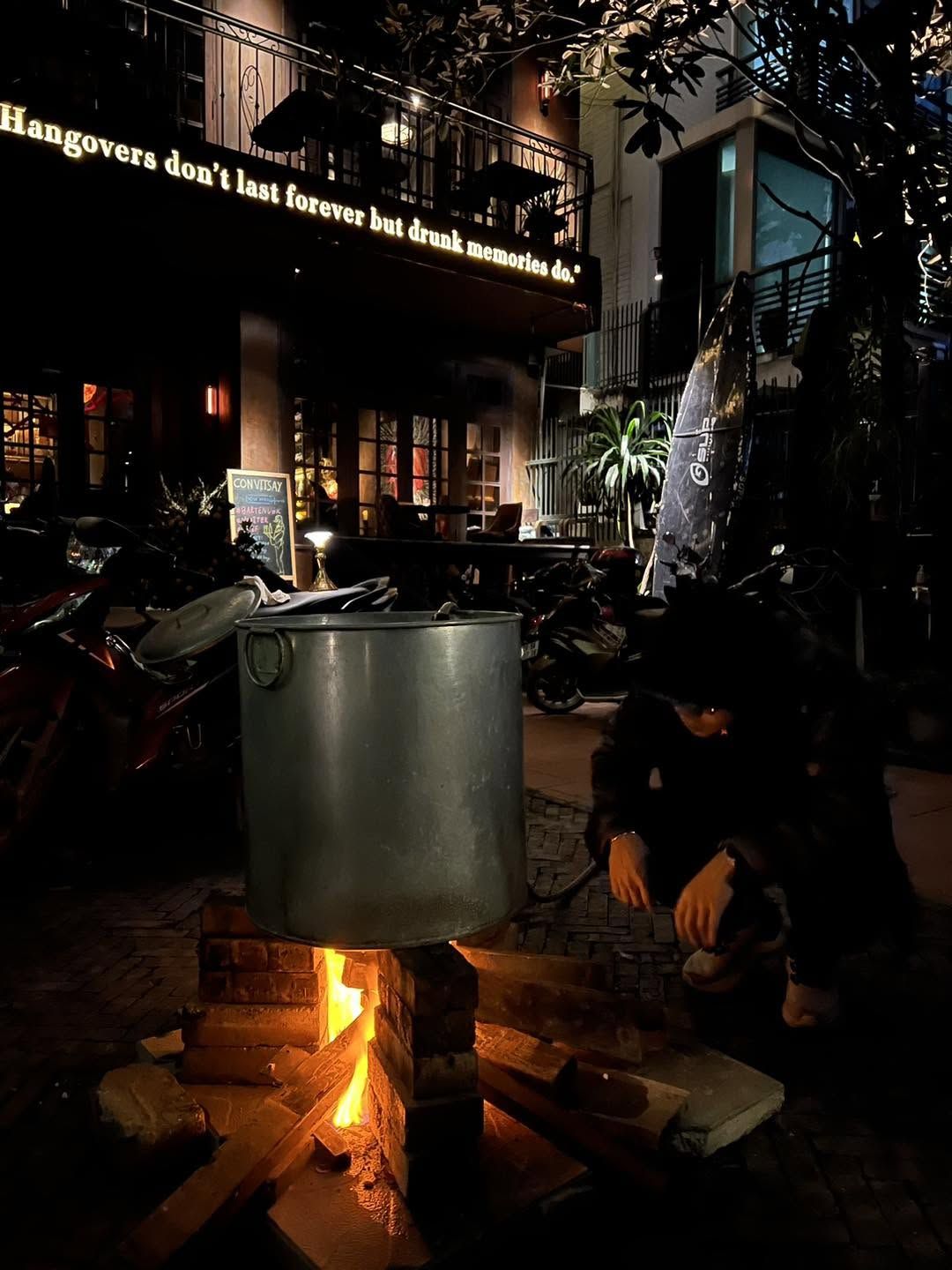 Bánh chưng boiling over a wood fire in front of the house